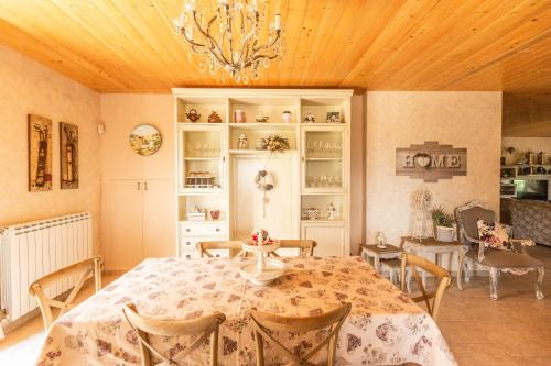 a dining room with a table and chairs and a chandelier at Villa Le Cicale - Irpinia in Prata di Principato Ultra