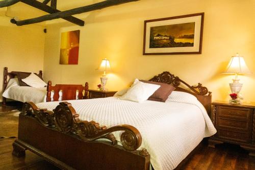 a bedroom with two large beds and two lamps at Hacienda San Isidro Trails & Experiences in Cotacachi