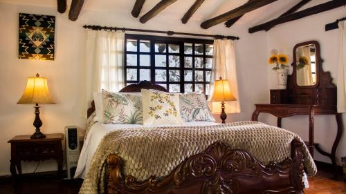 a bedroom with a bed with pillows and a window at Hacienda San Isidro Trails & Experiences in Cotacachi