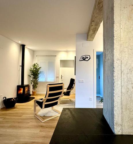 a living room with two chairs and a fireplace at San Xuan Resort in San Juan de Nieva