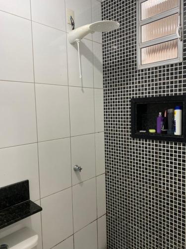 a bathroom with a shower with black and white tiles at Casa temporada Guarapari in Guarapari