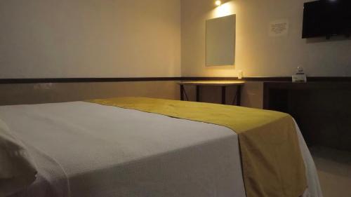 a bedroom with a bed with a yellow blanket on it at Hotel Maioris La Paz in La Paz
