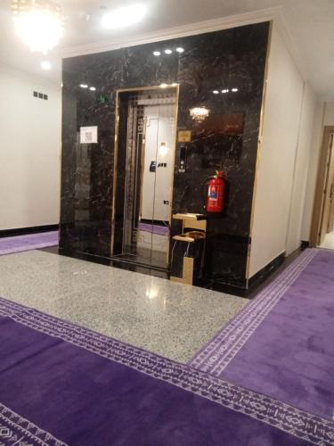 a room with a lobby with purple floors and a door at Orchid Hotel Madinah in Al Madinah