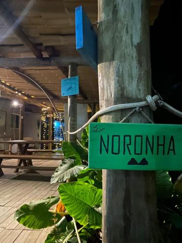 a green sign that says norona attached to a pole at Pousada Porto de Paz - Noronha in Fernando de Noronha