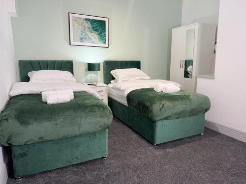 two beds sitting next to each other in a bedroom at Portman Greens 3BR Entire Home in Middlesbrough