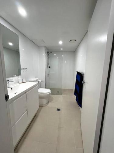 a white bathroom with a toilet and a sink at Shoal Vibes in Shoal Bay
