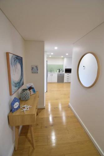 a hallway with a table and a mirror on a wall at Shoal Vibes in Shoal Bay