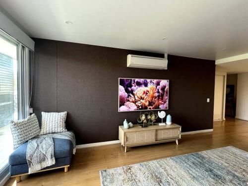 a living room with a couch and a painting on the wall at Shoal Vibes in Shoal Bay