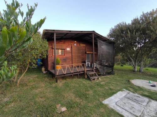a small wooden cabin with a porch in a yard at Almar in La Paloma