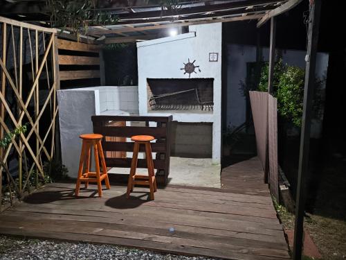 two stools sitting on a wooden deck with a stove at Almar in La Paloma