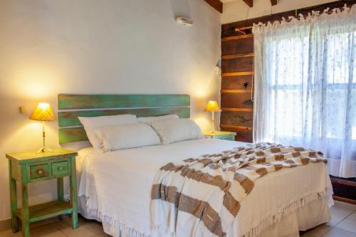 a bedroom with a large bed and a window at Samai Suma Cabañas & Spa in Villa General Belgrano