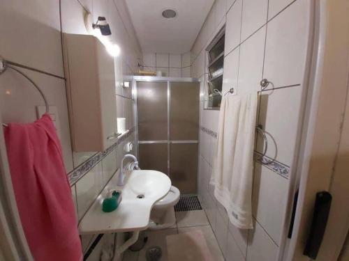 a bathroom with a toilet and a sink and a shower at Casa com Piscina na Enseada in Guarujá