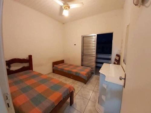a bedroom with two beds and a refrigerator at Casa com Piscina na Enseada in Guarujá