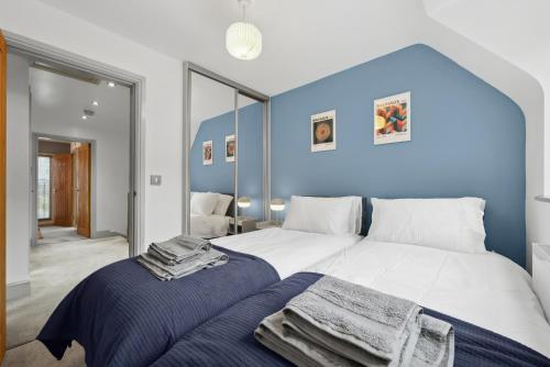 a bedroom with a white bed and a blue wall at NEC Birmingham Airport Modern Village Retreat, Sleeps 7, Free Parking in Hampton in Arden
