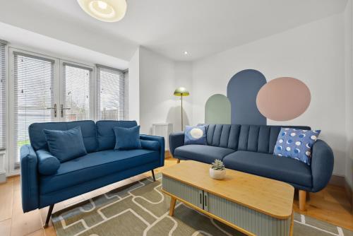 a living room with two blue couches and a table at NEC Birmingham Airport Modern Village Retreat, Sleeps 7, Free Parking in Hampton in Arden
