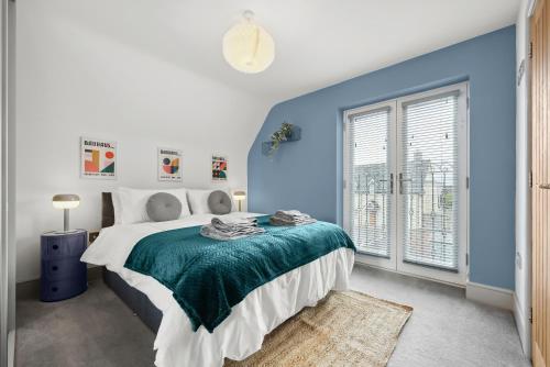 a blue and white bedroom with a bed and a window at NEC Birmingham Airport Modern Village Retreat, Sleeps 7, Free Parking in Hampton in Arden