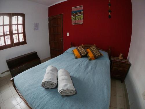 a bedroom with a bed with towels on it at Imaynalla Humahuaca Hostl in Humahuaca