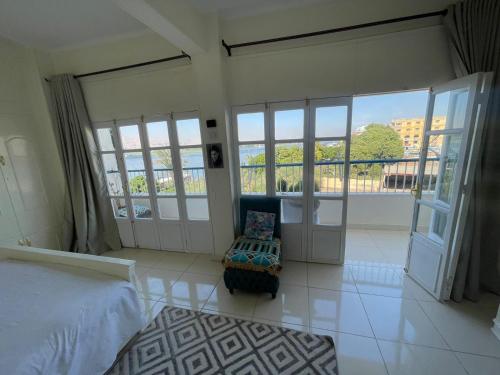 a bedroom with a bed and a balcony with windows at luxor Nile view duplex apartment in Luxor