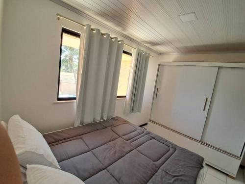 a small bedroom with a bed and a window at Casa aconchegante perto da praia in Salvador