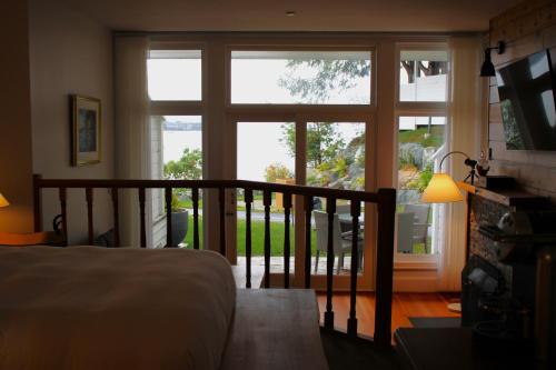 a bedroom with a bed and a large window at Sooke Harbour House in Sooke