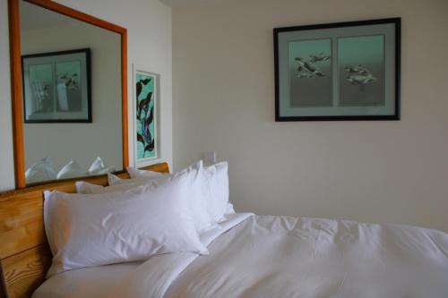 a bed with white sheets and pillows on it at Sooke Harbour House in Sooke