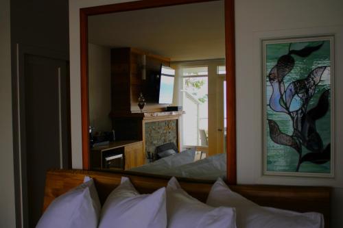 a bedroom with a large mirror over a bed at Sooke Harbour House in Sooke