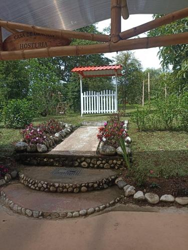 a garden with a white gate and some flowers at Green Bamboo Lodge in San Francisco de Borja