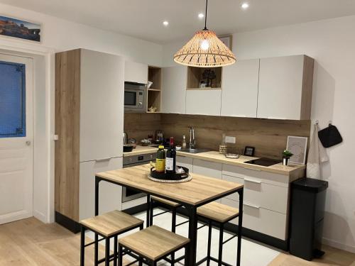 une cuisine avec une table et des tabourets dans l'établissement Paris - Elégant Apt Rue Mouffetard - Prestation de Luxe, à Paris