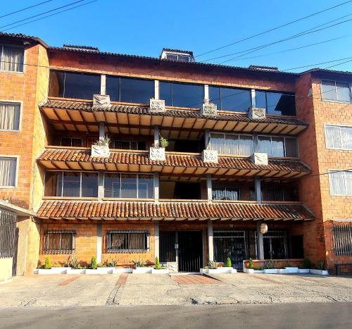 a red brick building with windows on the side of it at Dep El Colibrí con parqu in Cuenca