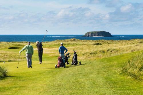 a group of people playing golf on a golf course at LILY'S LODGE - Beautiful Central Buncrana Home in Buncrana