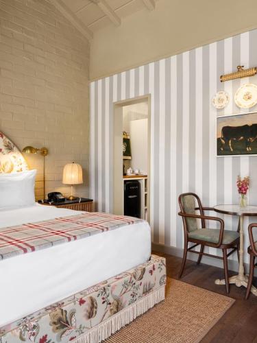 a bedroom with a bed and a table with a chair at Le Petit Pali Brentwood in Los Angeles