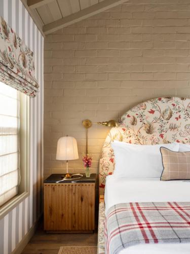 a bedroom with a bed and a table with a lamp at Le Petit Pali Brentwood in Los Angeles