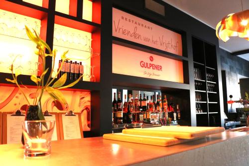 a bar with a display of bottles of wine at Saillant Hotel Maastricht City Centre - Auping Hotel Partner in Maastricht