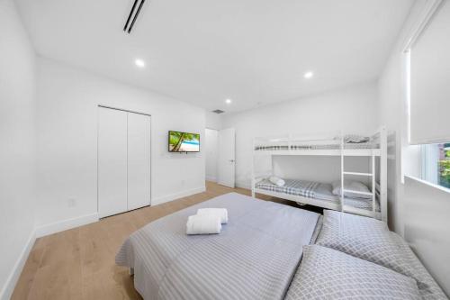 a white bedroom with a bed and bunk beds at Up to 12 guest Modern Villa near Wynwood! 27 in Miami