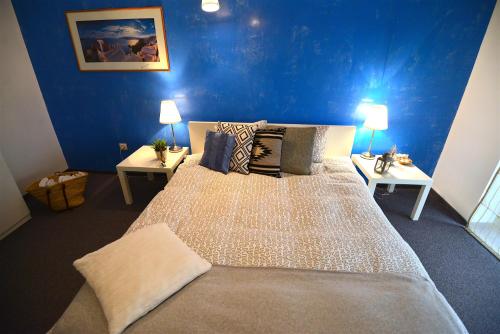 a bedroom with a large bed with blue walls at Hotel Biscuit in Cluj-Napoca