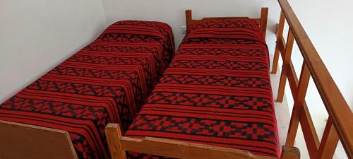 two beds on the side of a stair case at El nuevo amanecer mar de ajó in Mar de Ajó