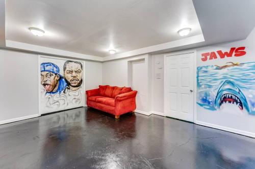 a red chair in a room with paintings on the walls at Unwind & Relax at Legacy Estates in Stone Mountain