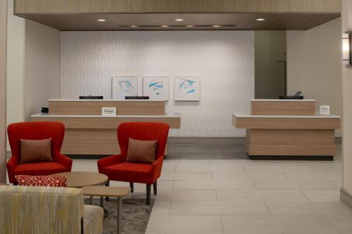 a waiting room with two red chairs and a counter at Hilton Garden Inn Tacoma Downtown in Tacoma