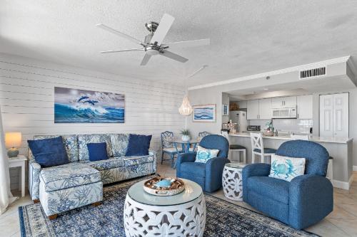 a living room with blue furniture and a kitchen at Magnolia House 307 At Destin Pointe Resort in Destin