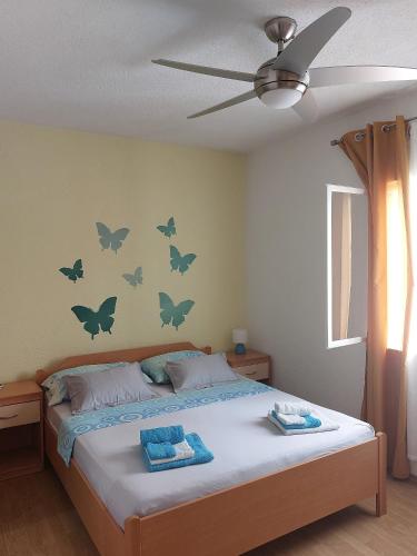 a bedroom with a bed with butterflies on the wall at Apartments with parking space Postira, Brac - 2911 in Postira