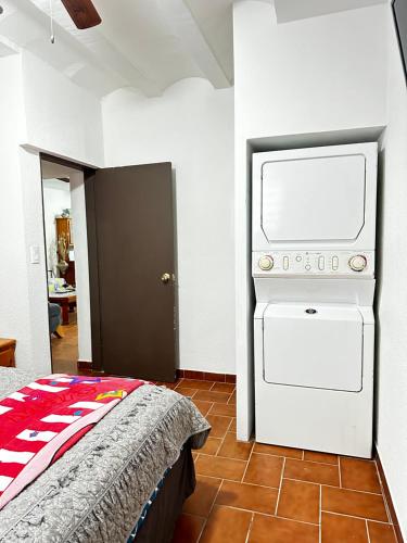 a bedroom with a washer and dryer on the wall at Palacio de cristal, Fiesta de cortes 101, Casa Hermar in Puerto Peñasco