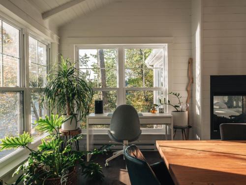 a room with a desk and some plants and windows at The Owl's Nest - Lakeside peacefulness ski & hiking in Austin