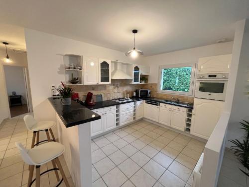 une cuisine avec des armoires blanches et des appareils électroménagers blancs dans l'établissement Apartment in Carantec near Sandy Beaches, à Carantec