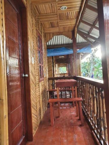 a wooden porch with a bench on a balcony at MarineroTravellers Inn in San Vicente
