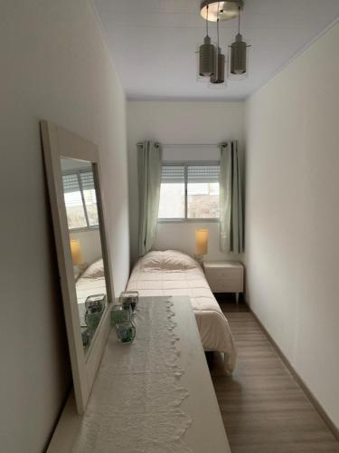 a small bedroom with a mirror and a bed at La Perla in Nueva Helvecia
