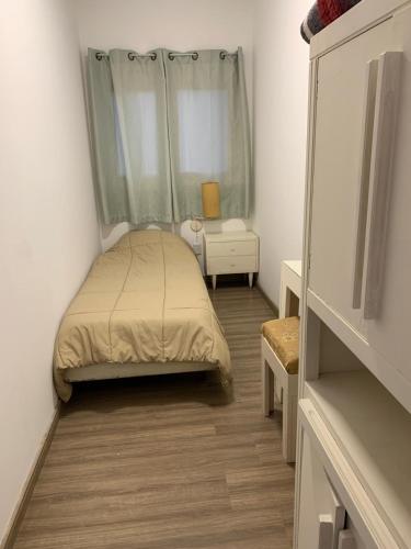 a small bedroom with a bed and a window at La Perla in Nueva Helvecia