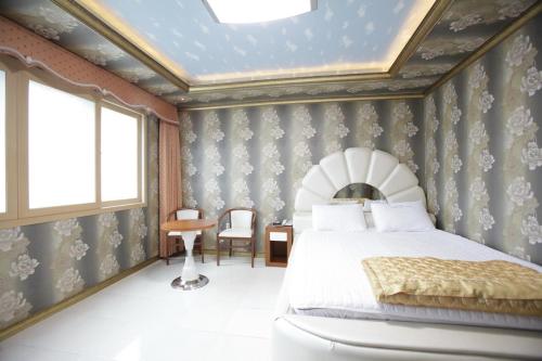 a bedroom with a large bed and a ceiling at Pataya Motel in Geoje 