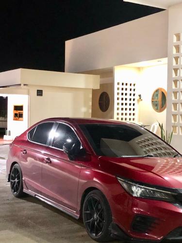 a red car parked in front of a building at บ้านศรีสุธรรม 2 Baansrisuthum 2 in Surat Thani