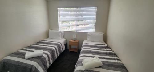 two twin beds in a room with a window at Bayview Waters Apartments in Gold Coast