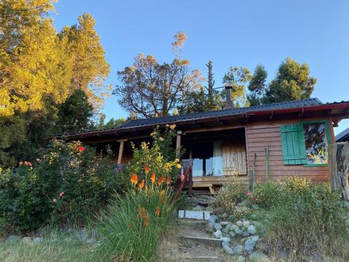 una piccola casa in legno con un giardino di fronte di Pico Andino a San Carlos de Bariloche